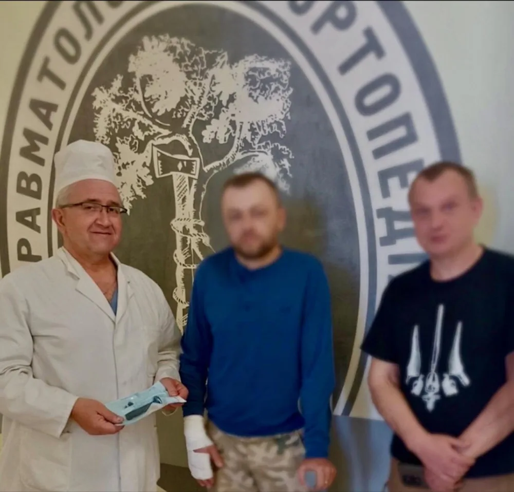 Лікар з пацієнтами біля емблеми клініки