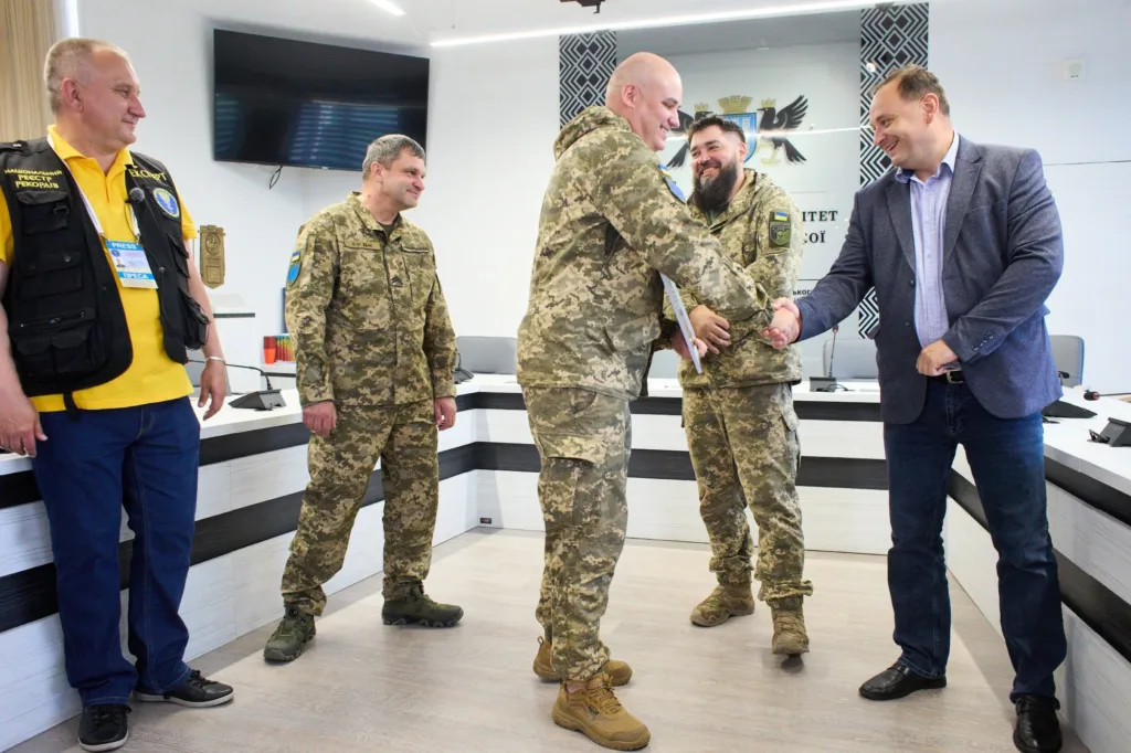Військові тиснуть руки цивільному в офісі