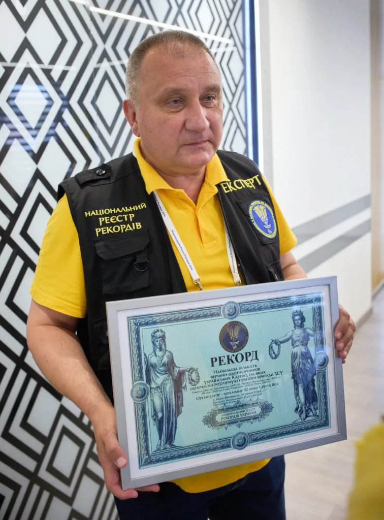 Чоловік тримає сертифікат Національного реєстру рекордів