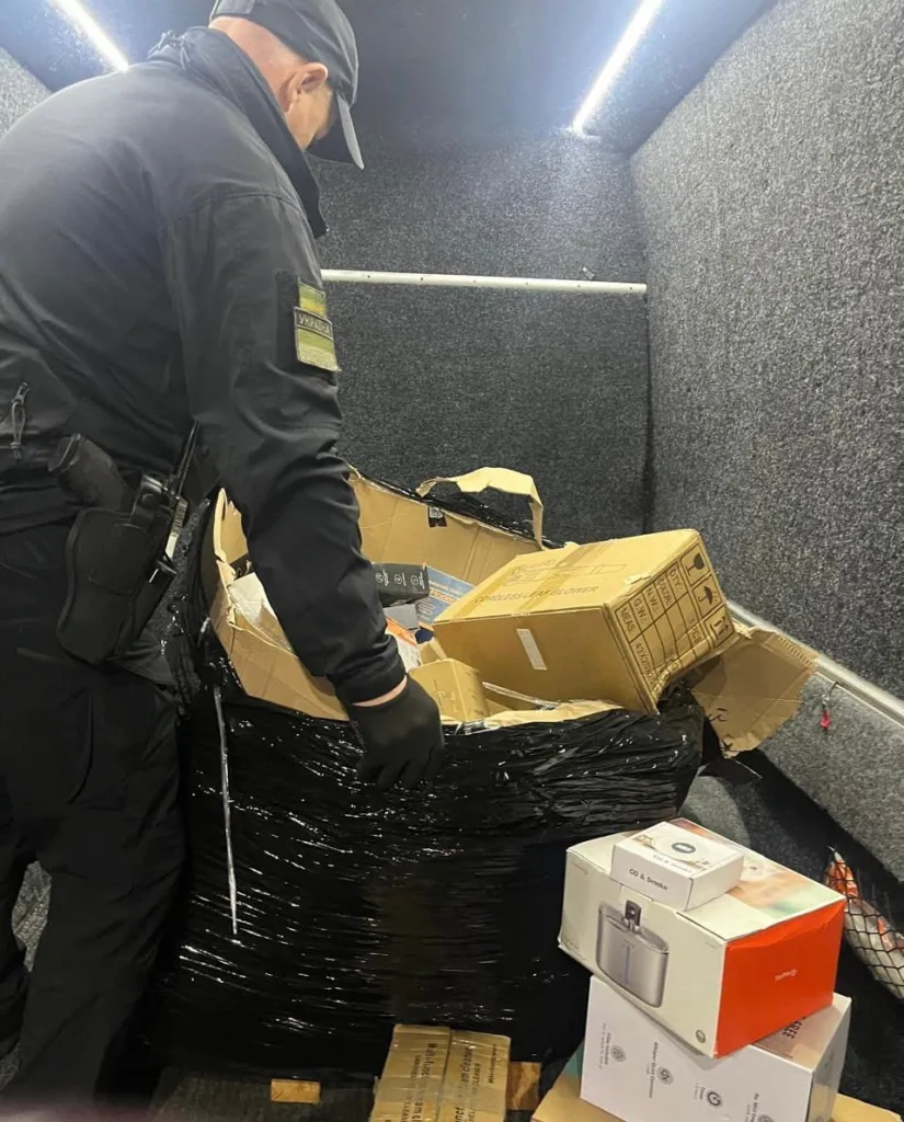 Поліцейський перевіряє коробки з товарами в машині