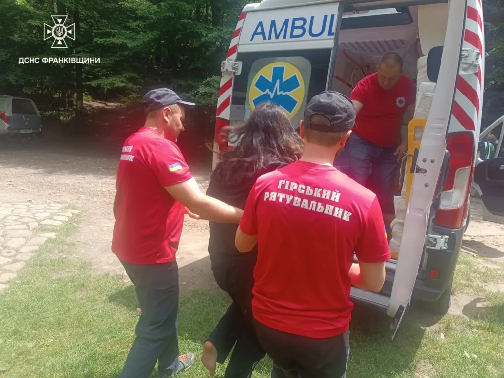 Рятувальники допомагають постраждалій біля швидкої допомоги