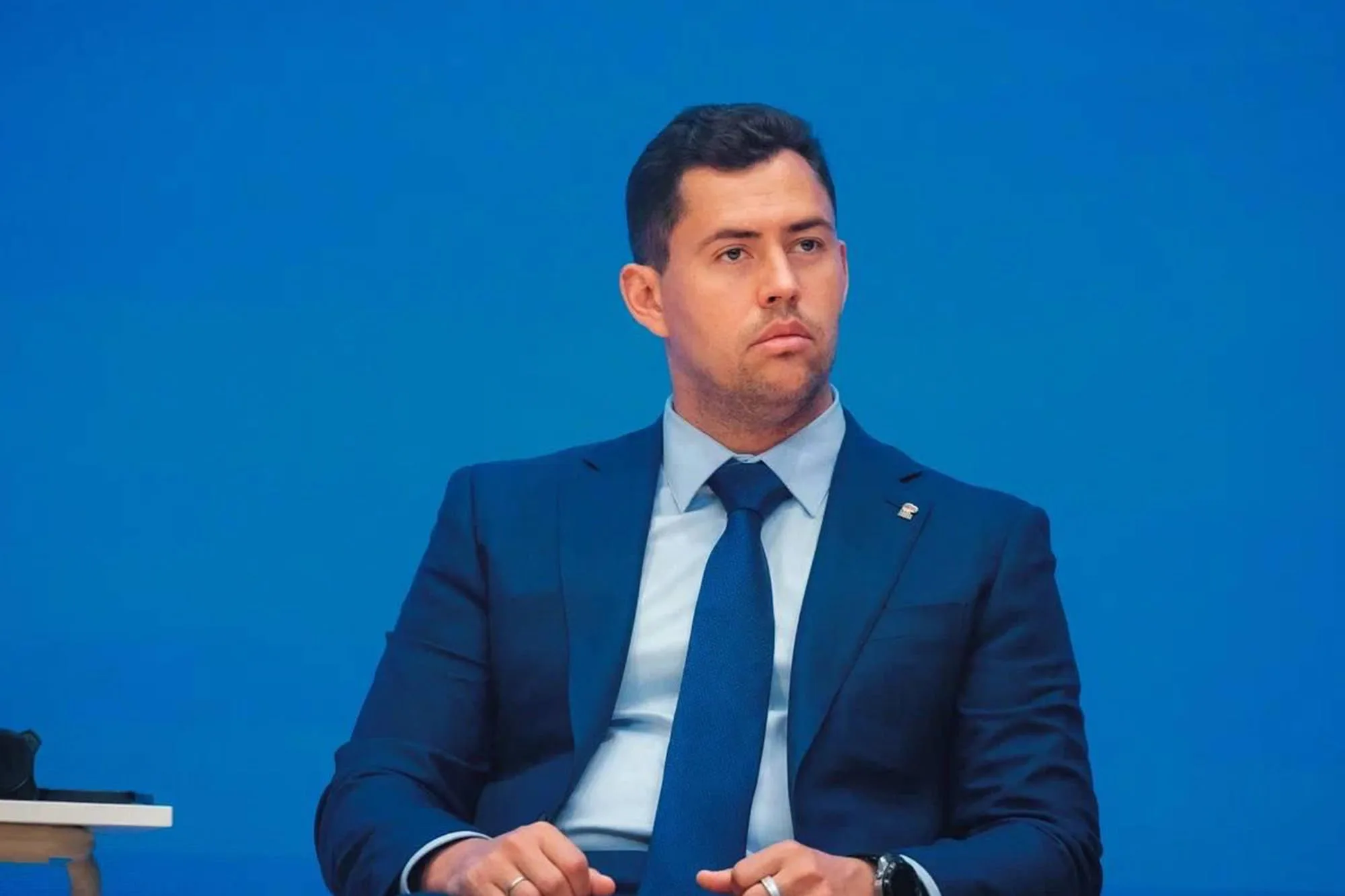 Чоловік у синьому костюмі на синьому тлі