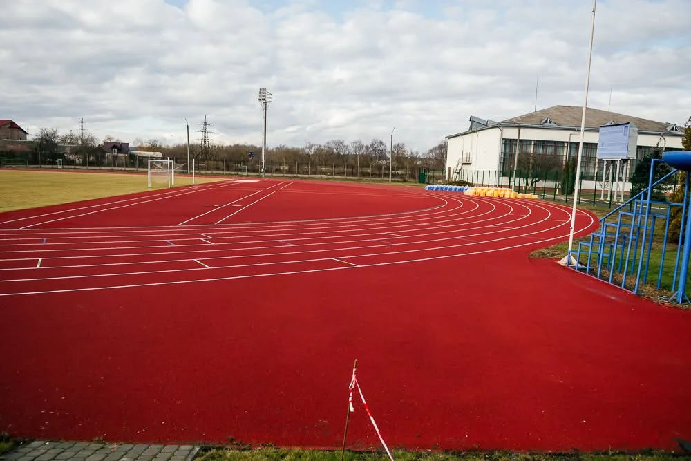 Червона бігова доріжка на спортивному стадіоні