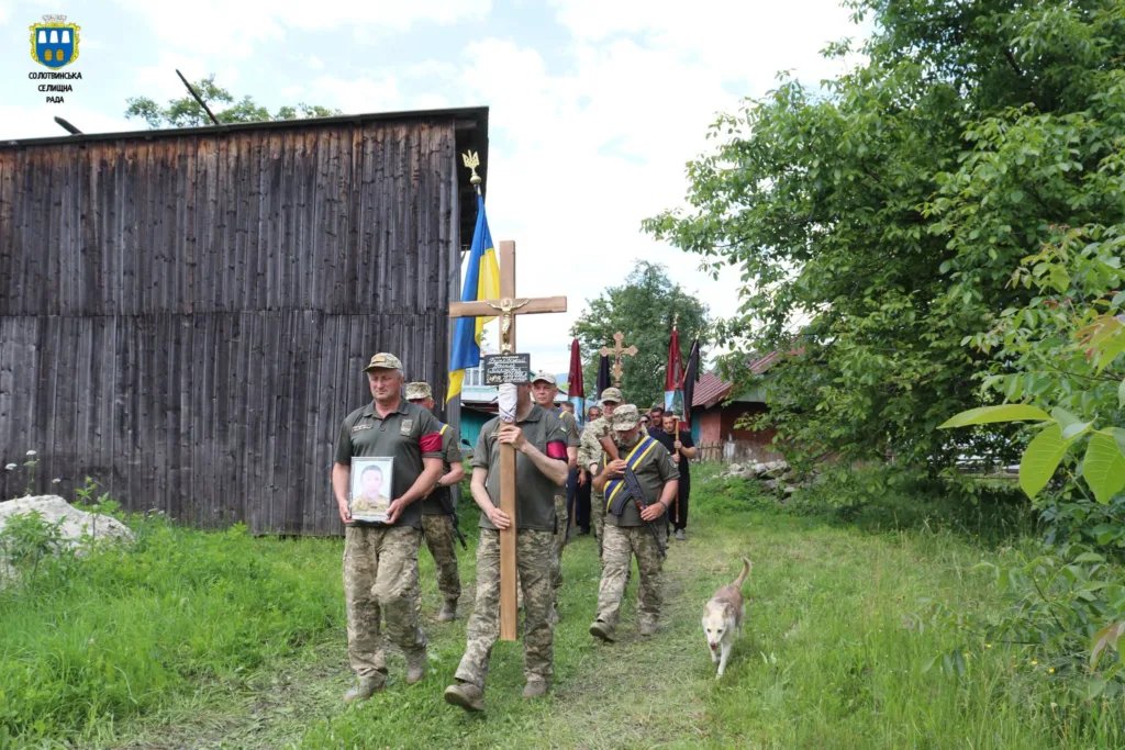 Військові несуть хрест і прапори на церемонії