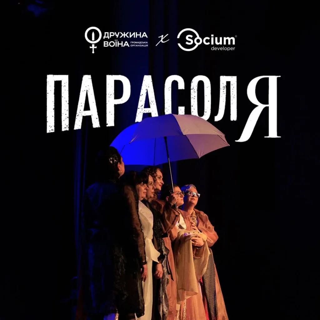Жінки під фіолетовою парасолею на сцені