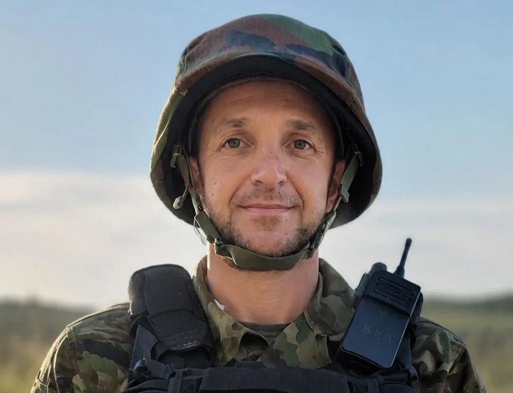Військовий у камуфляжі з рацією на полі