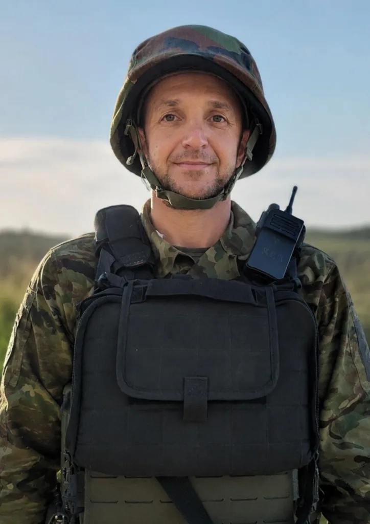 Військовий у камуфляжі з бронежилетом на природі