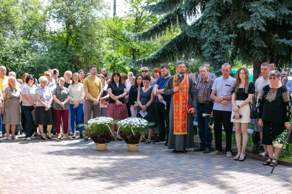 Люди на вуличній церемонії пам’яті з квітами