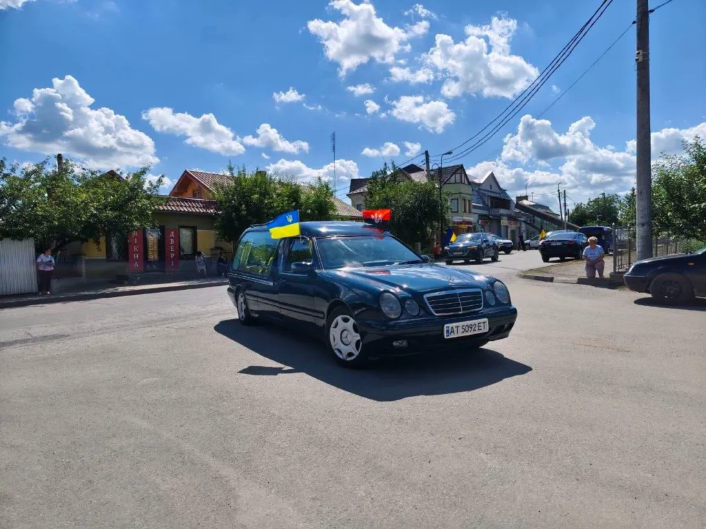 Катафалк із прапором України на міській вулиці