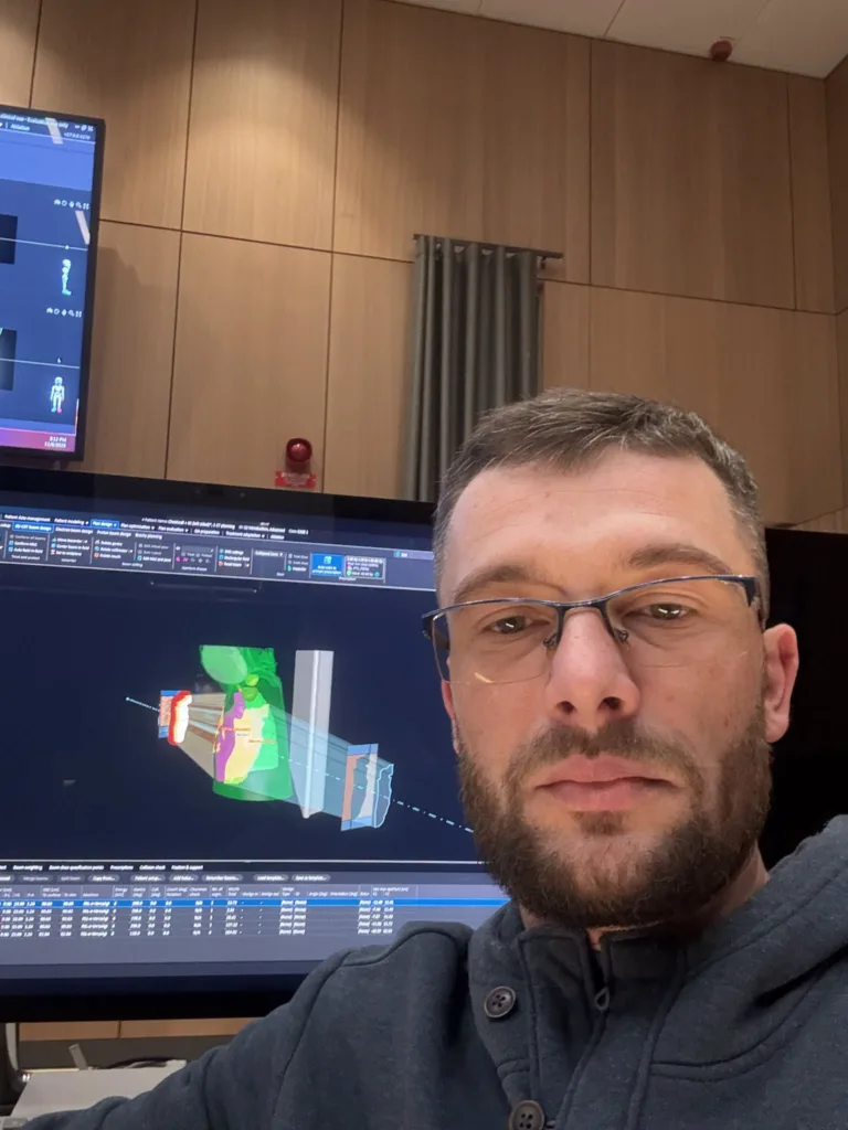 Чоловік перед комп’ютером із технічними схемами на екрані