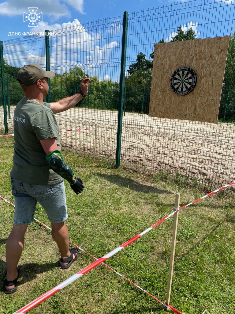 Чоловік кидає дротик у мішень на відкритому майданчику