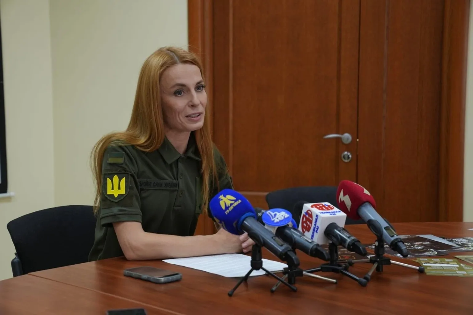 Жінка у військовій формі на пресконференції
