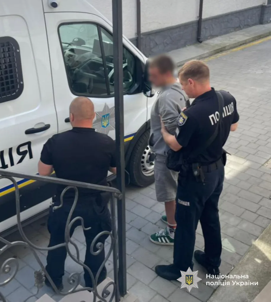 Поліція України затримує підозрюваного біля автівки