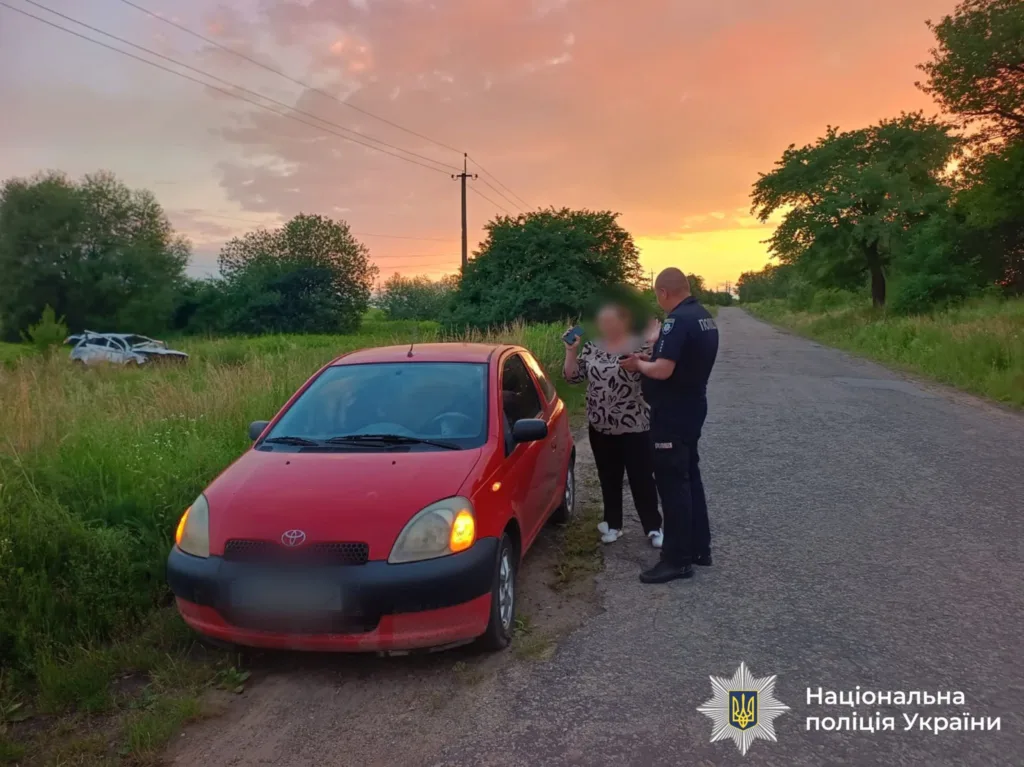 Поліцейський перевіряє водія червоного автомобіля