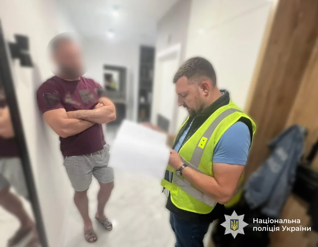 Поліцейський проводить обшук у квартирі чоловіка
