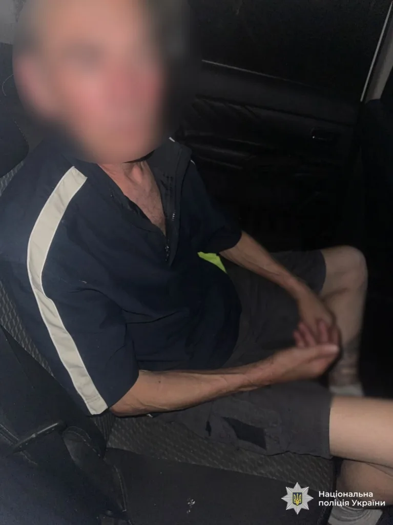 Чоловік сидить у поліцейській машині