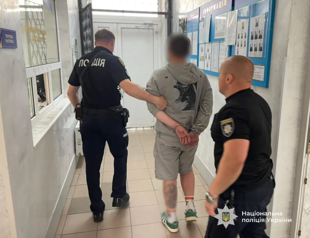 Поліція веде затриманого коридором відділку