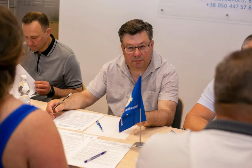 Чоловік підписує документи на зустрічі