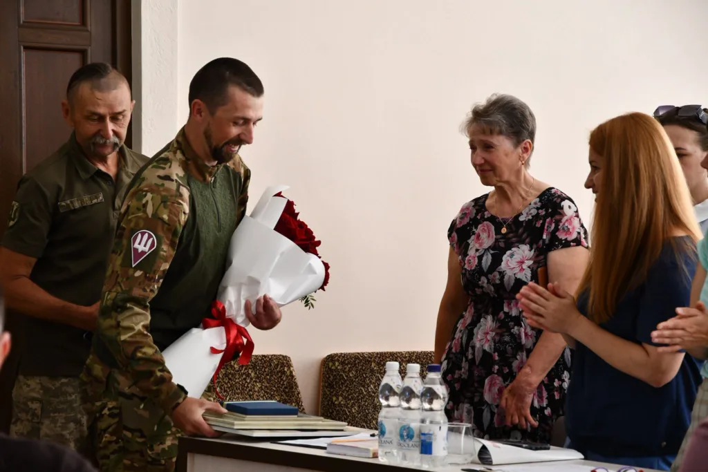 Військовий отримує квіти під час церемонії нагородження