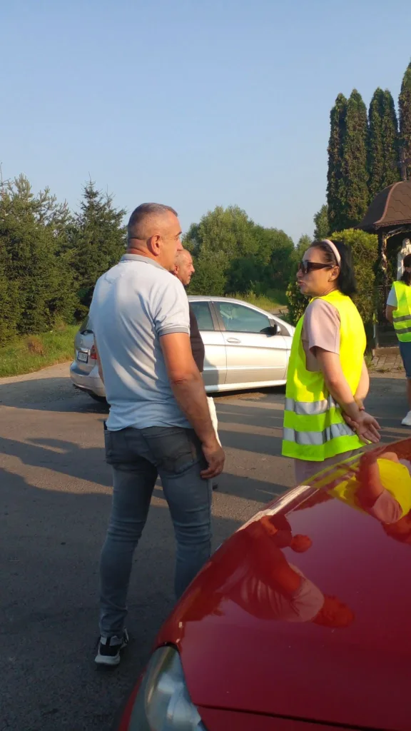 Люди спілкуються біля машин на дорозі