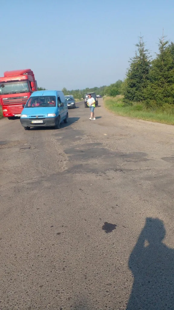 Люди й автомобілі на сільській дорозі