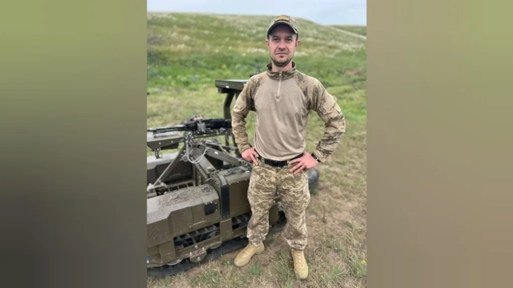 Військовий у камуфляжі поруч із технікою на полі