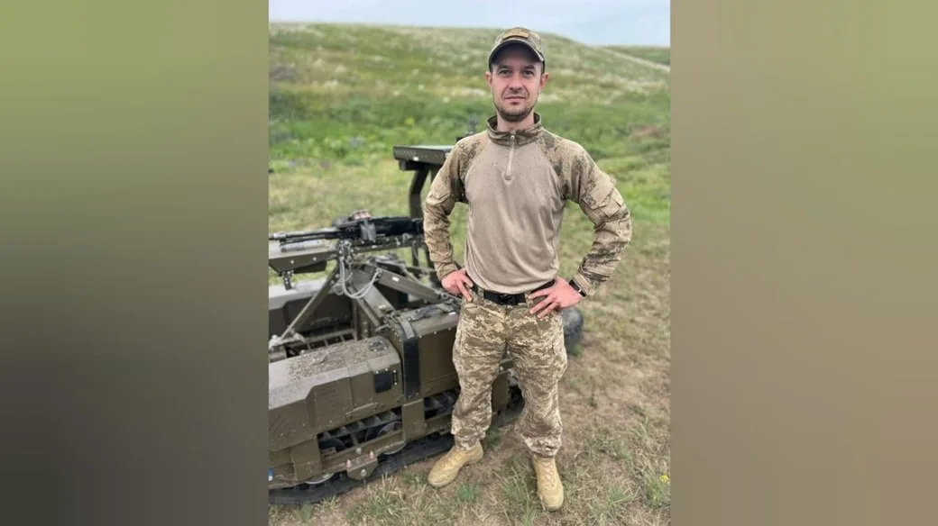 Військовий у камуфляжі поруч із технікою на полі