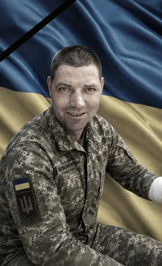 Український військовий перед прапором України