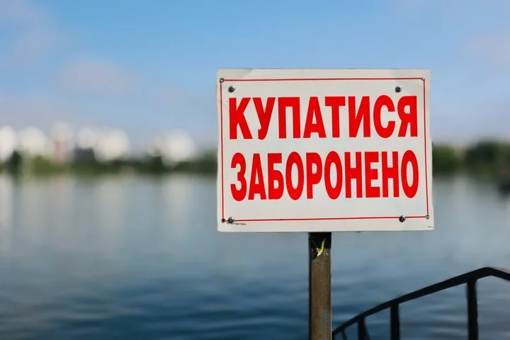 Знак біля водойми з написом купатися заборонено