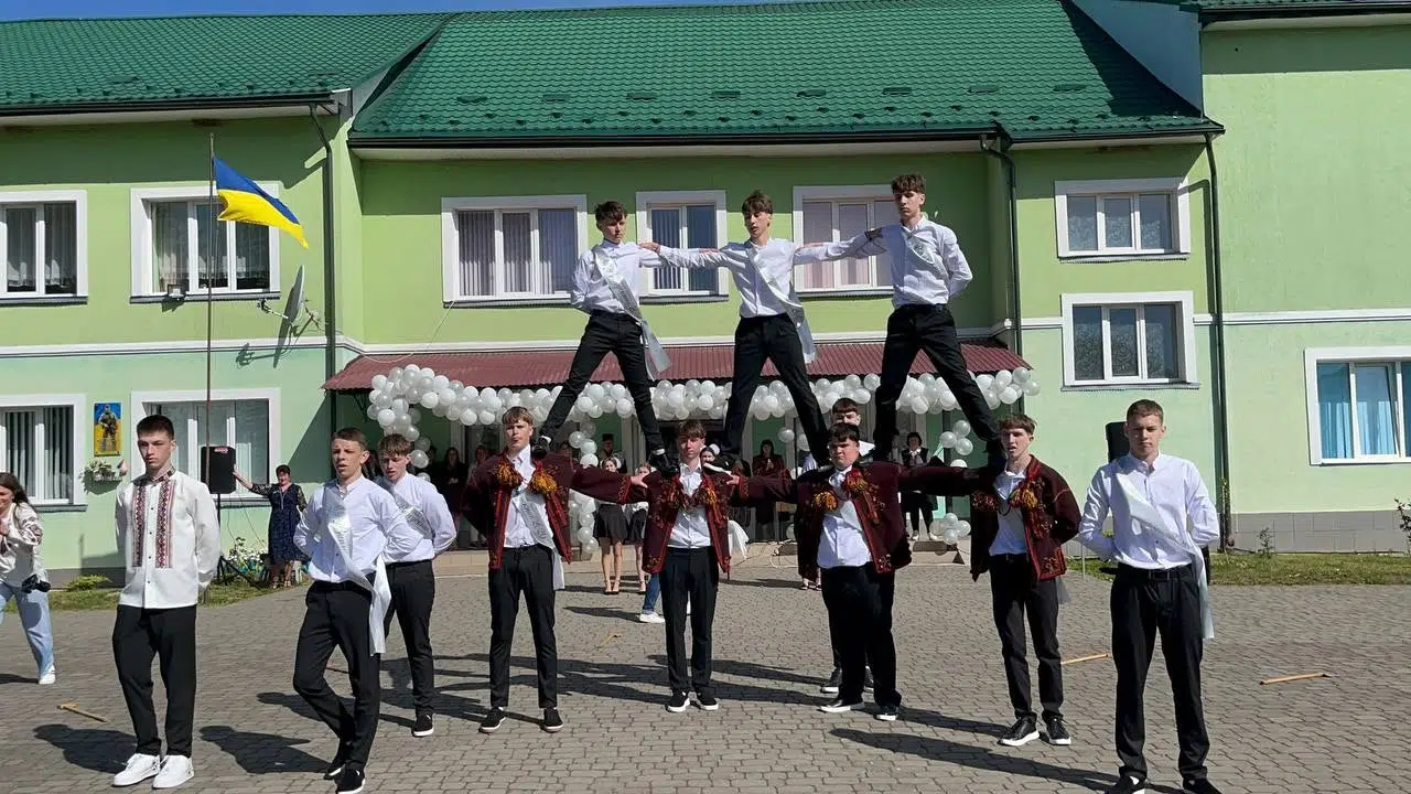 Учні виконують акробатичний номер перед школою