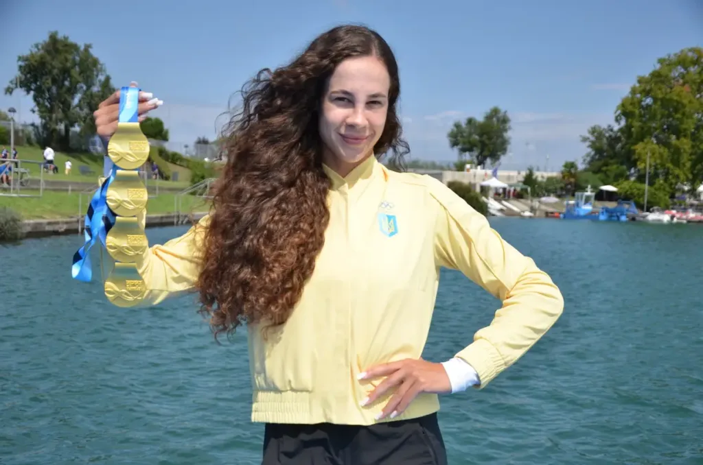 Українська спортсменка з золотими медалями біля води
