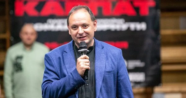 Чоловік виступає з мікрофоном на сцені