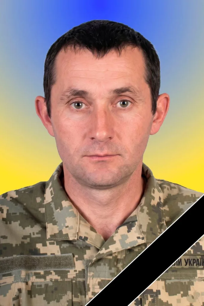 Український військовий у формі на фоні прапора