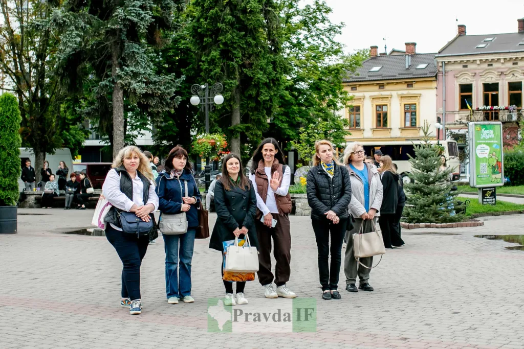 Група жінок стоїть на міській площі