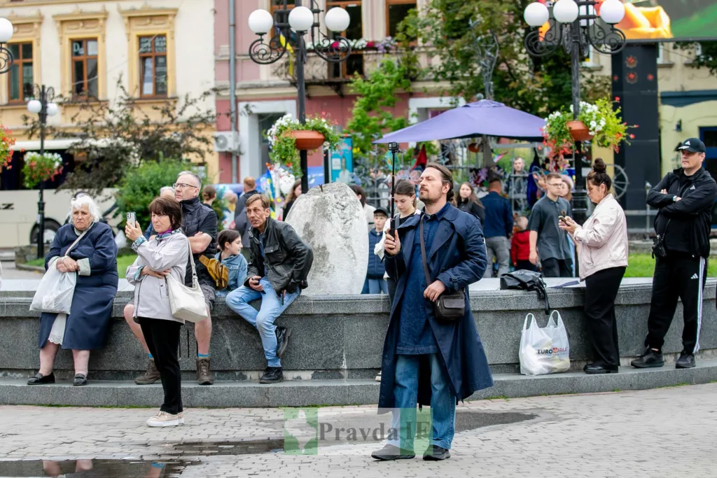 Люди на площі у місті спостерігають подію