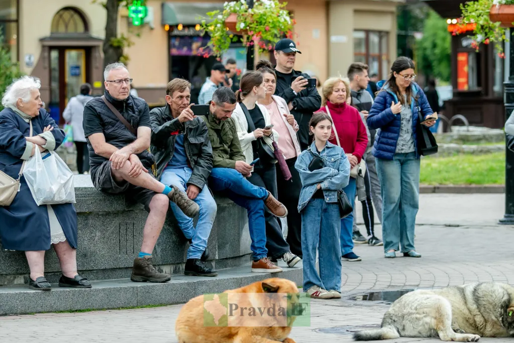 Люди сидять і стоять на міській площі