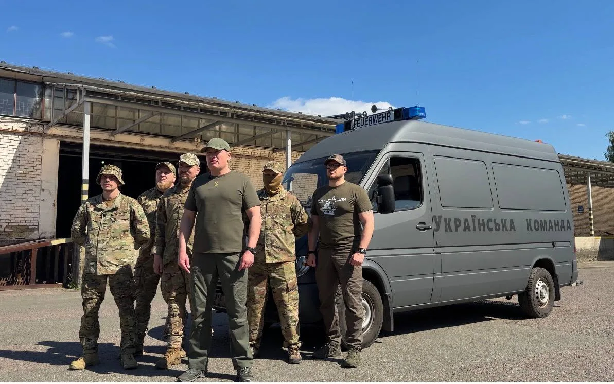 Військові стоять біля фургона Українська команда