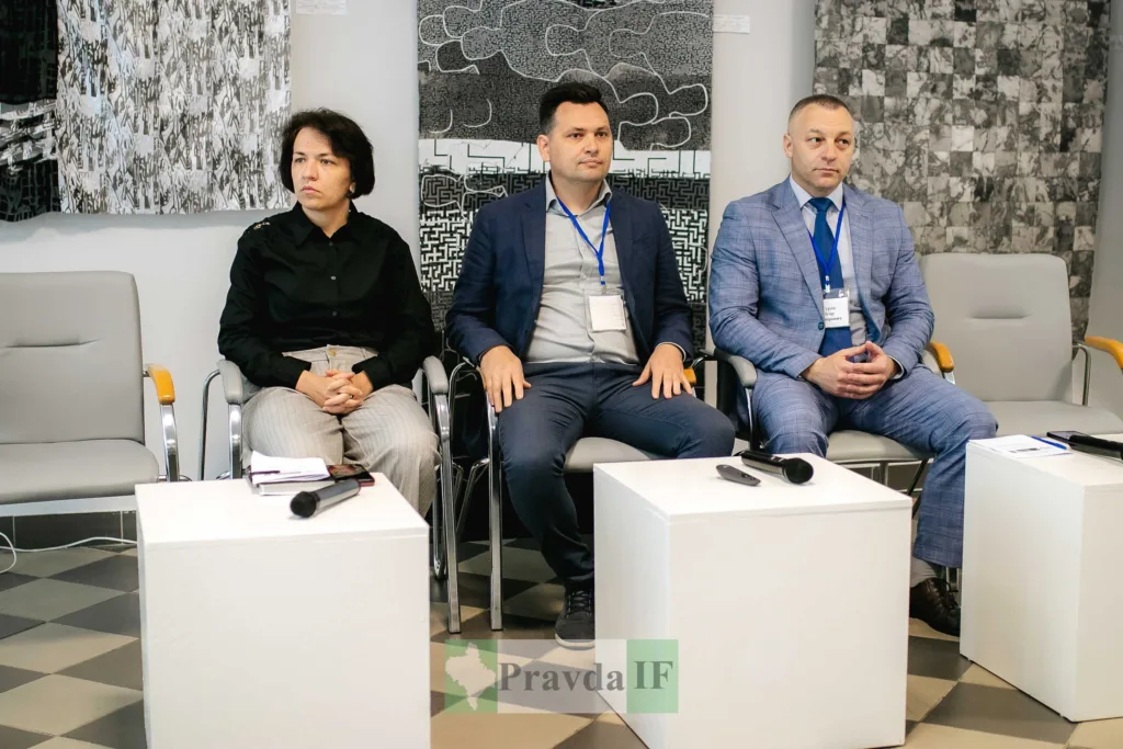 Троє людей сидять на конференції