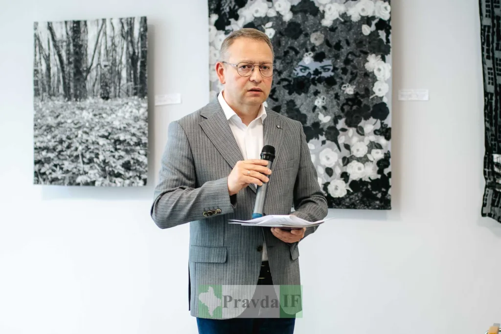 Чоловік виступає з мікрофоном на виставці мистецтва
