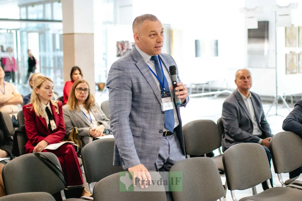 Чоловік виступає на конференції з мікрофоном