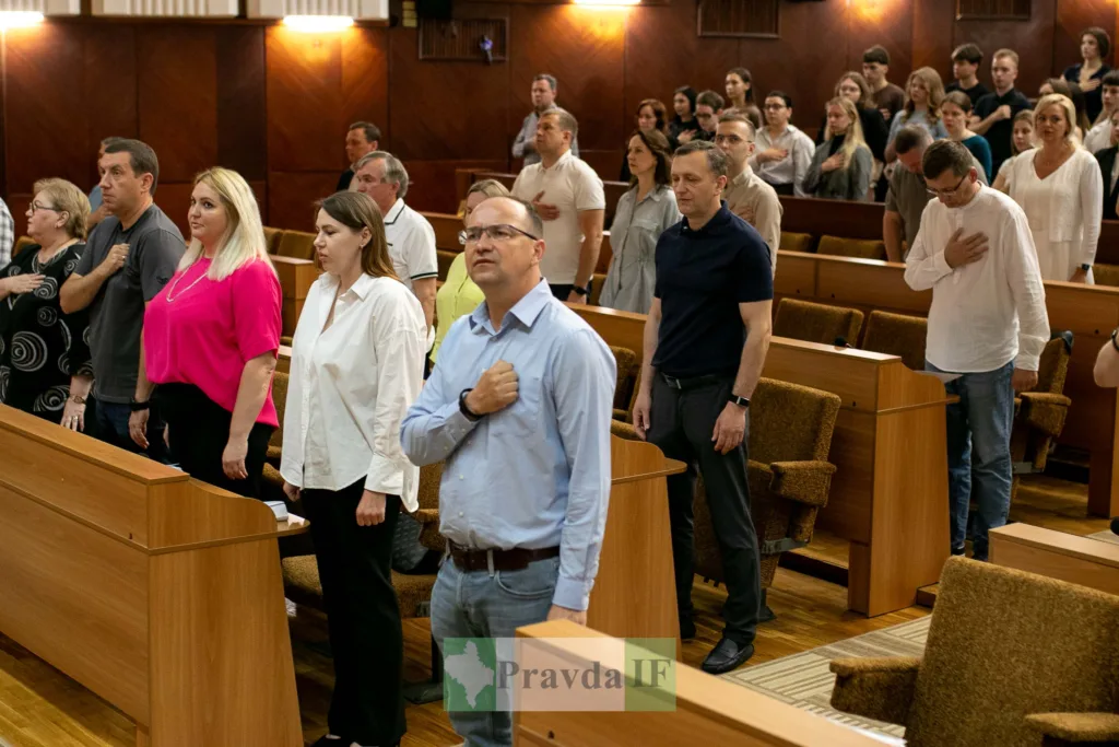 Люди стоять у залі під час офіційної церемонії