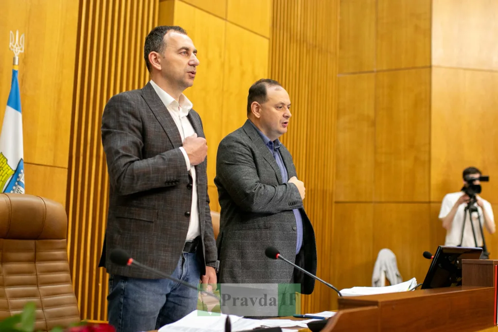 Депутати стоять під час засідання у залі ради