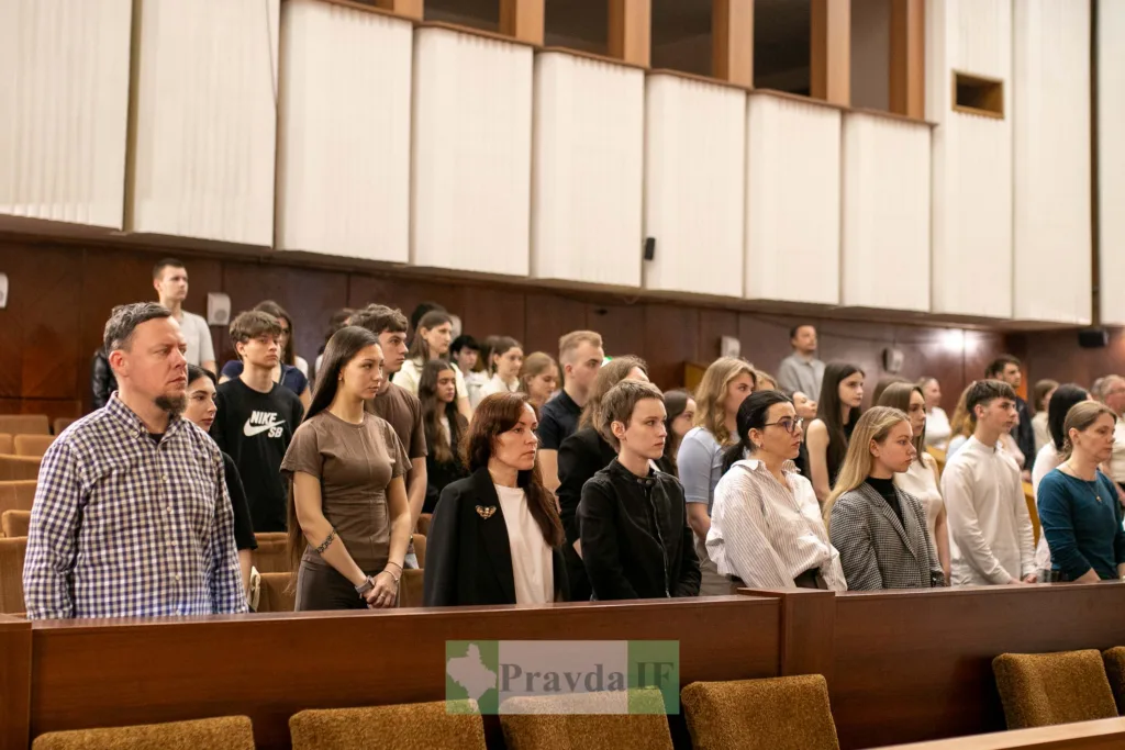 Люди стоять у залі під час офіційного заходу