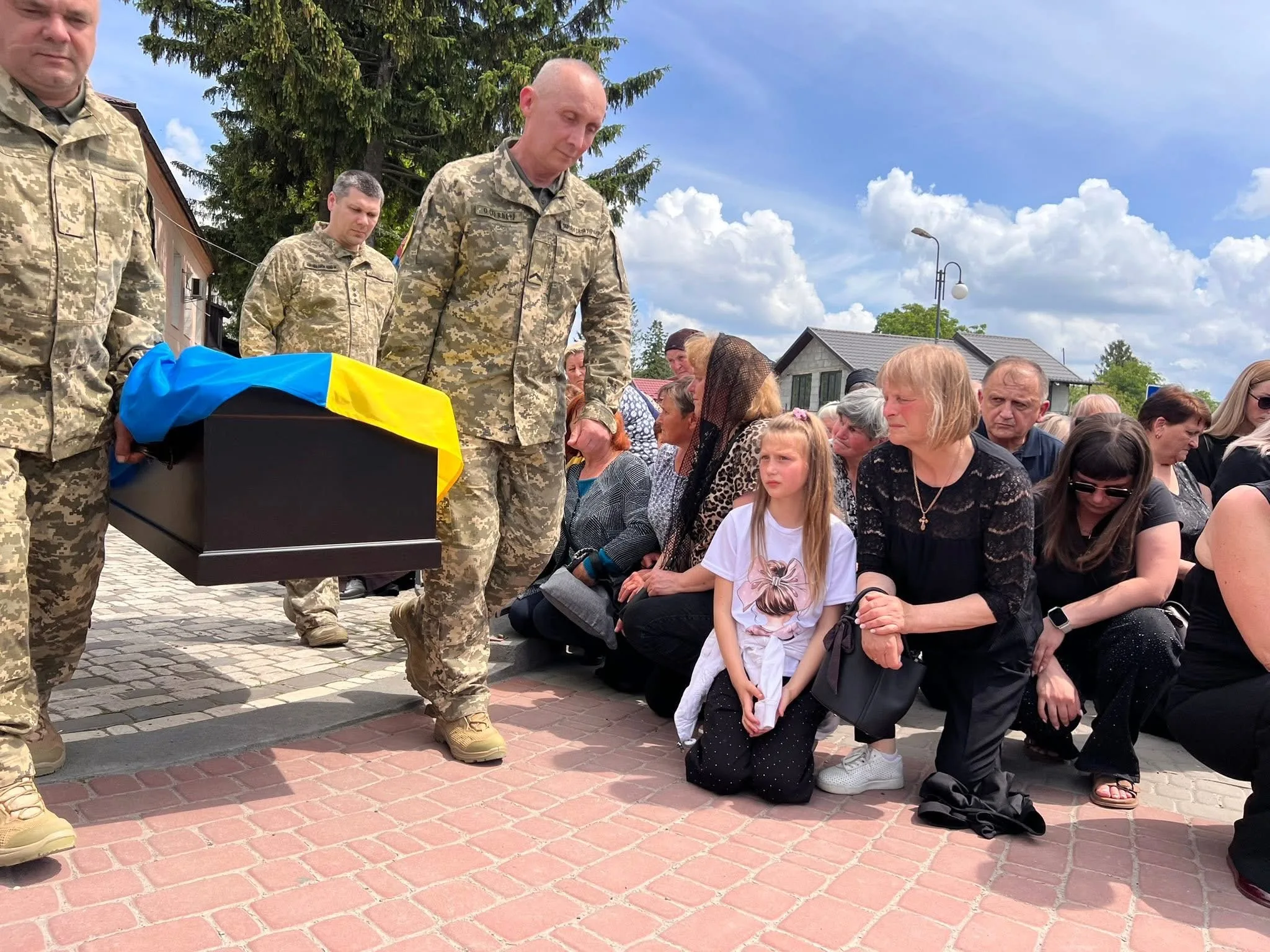 Похорон військового з труною, накритою українським прапором