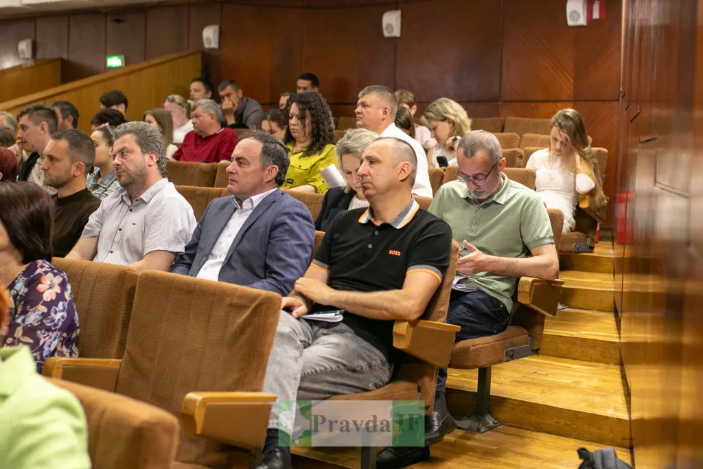 Люди сидять у залі під час конференції