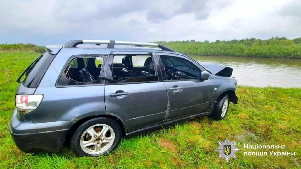 Розбитий автомобіль біля річки на траві