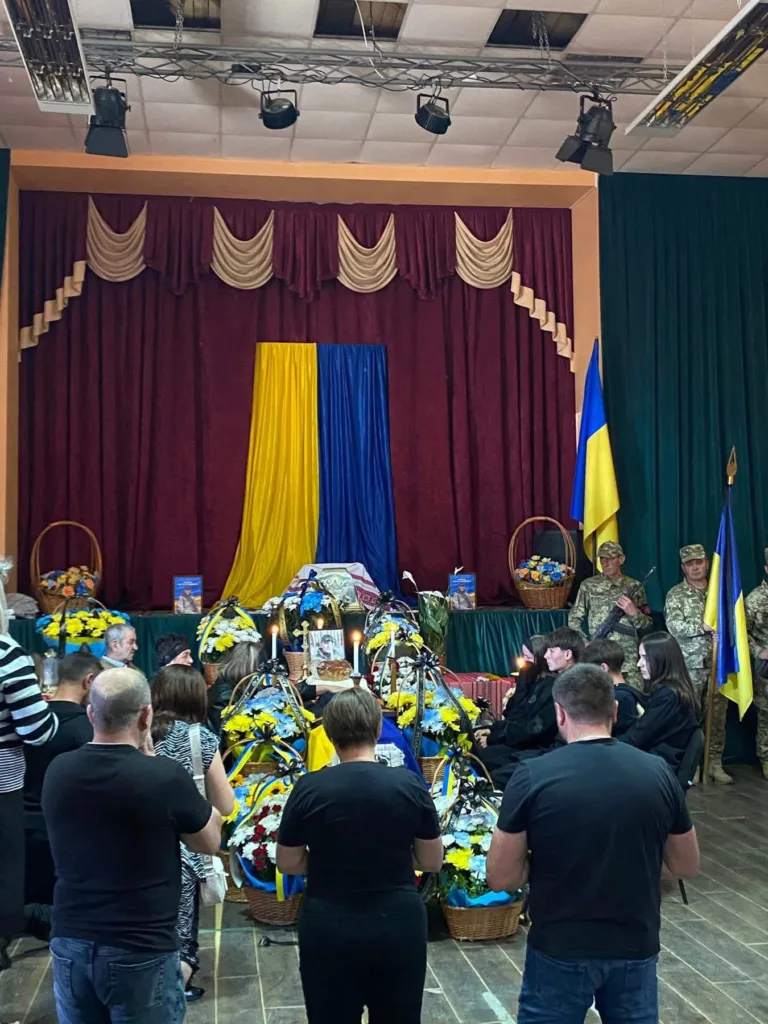 Прощання з воїном у залі з прапором України