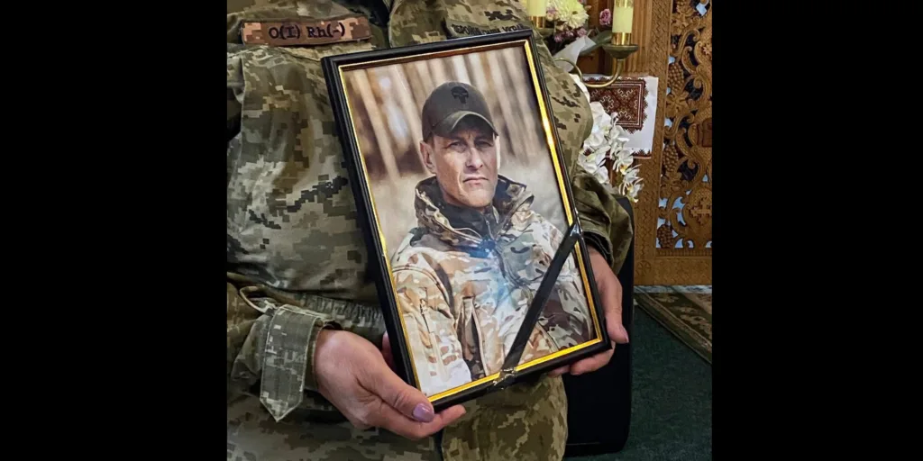 Військовий тримає портрет загиблого солдата