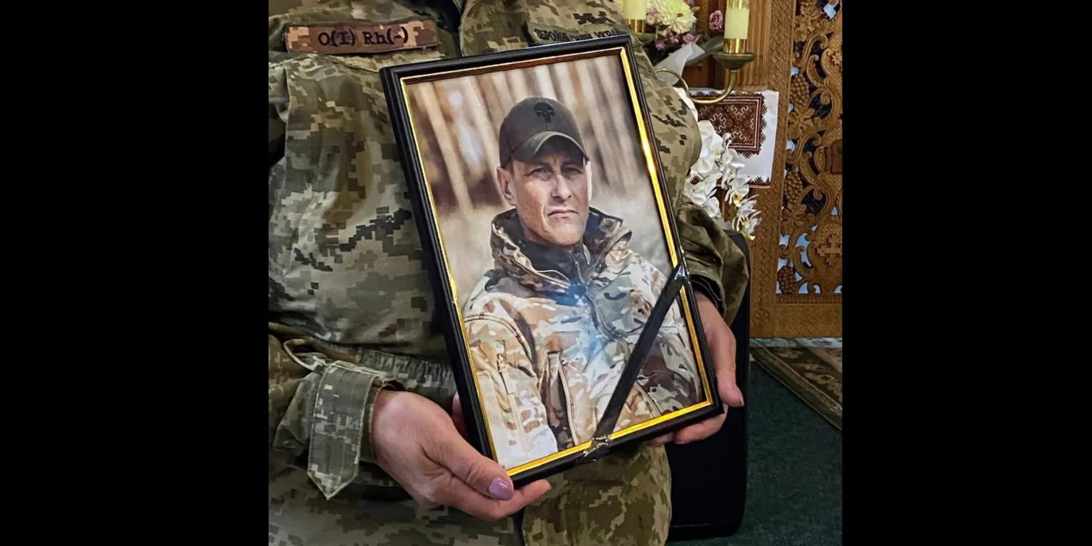 Військовий тримає портрет загиблого солдата