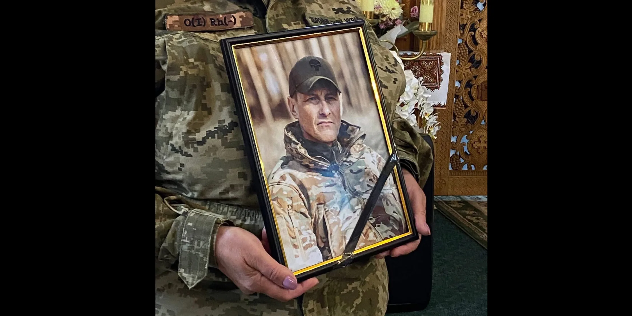 Військовий тримає портрет загиблого солдата